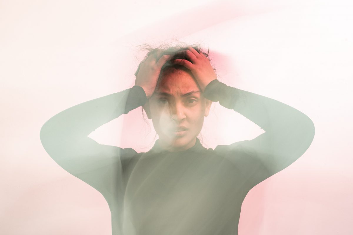 blurry stressed woman grabs head